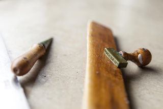 Typische Werkzeuge des Wachsziehers sind Stutzbrett, Handbohrer und Signierstempel